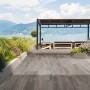 Eurostone Terrassenplatten TimberTwo Grigio, braungraues Feinsteinzeug in Holzoptik auf Terrasse am See.