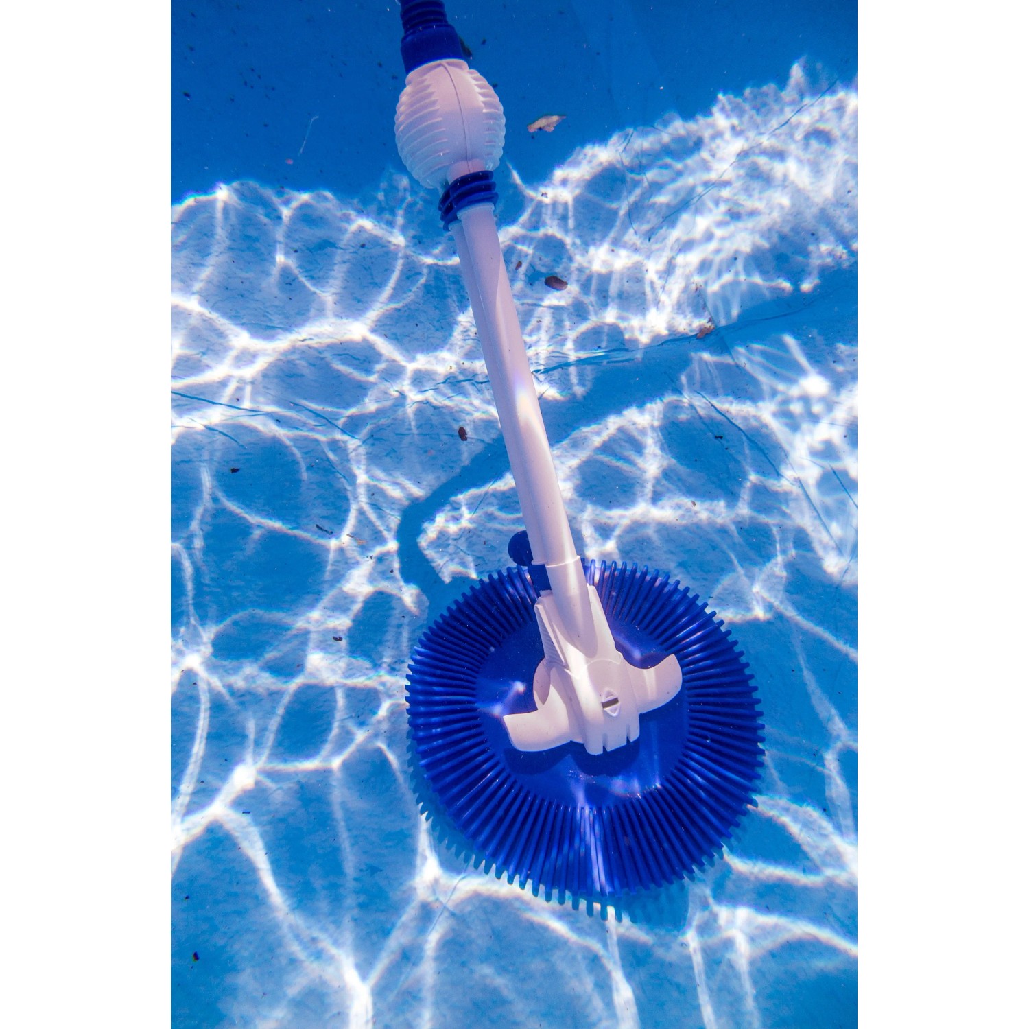 Weißer Gre Automatik-Poolreiniger mit blauem Bürstenkopf im Pool.