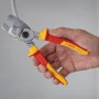 Bosch Professional VDE-Kabelschere (200 mm) schneidet Kabel. Zange mit rot-gelben Griffen in Hand.