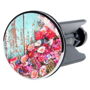 Sanilo Waschbeckenstöpsel Spring mit Blumenmuster vor türkisem Holz.