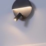 Schwarze, matte Trio LED Wandleuchte Mario mit Leselampe und Backlight an einer Wand.