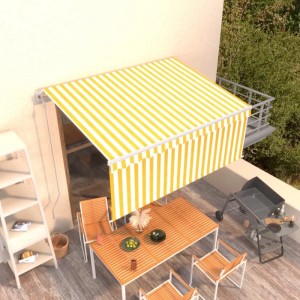Gelb-weiße vidaXL Markise mit Volant, ausgefahren über einer Terrasse mit Tisch und Grill.