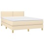 Cremefarbenes Boxspringbett mit Matratze, Stoffbezug, inklusive Kopfteil und Matratzenauflage.