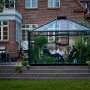 Juliana Gewächshaus Oase 13 Anthrazit mit Pflanzen und Personen im Garten.