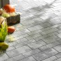 Verlegte, graue Mehrformat-Pflastersteine Parchetto Beton Grau-Alpin mit herbstlicher Dekoration.