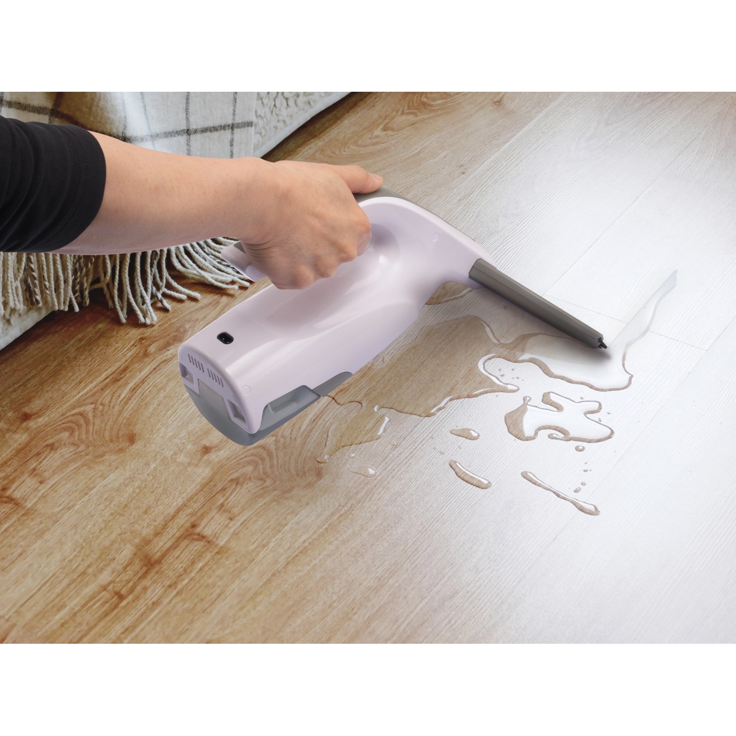 Akku-Fenstersauger im Einsatz auf Laminatboden mit Wasser.