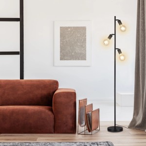 Schwarze Brilo Stehleuchte Kuglo mit drei schwenkbaren E27 Fassungen im Wohnzimmer.