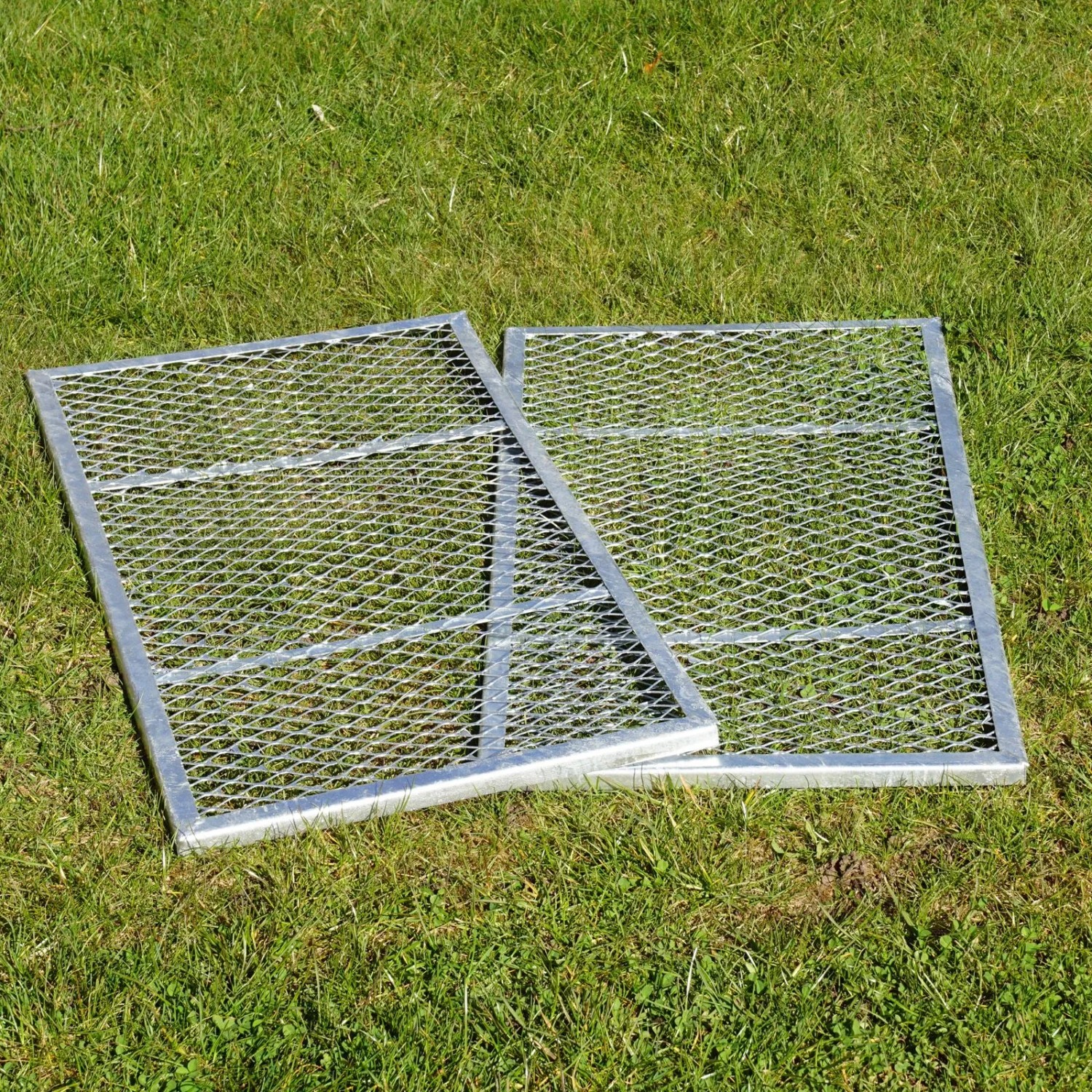 Zwei feuerverzinkte Streckmetall-Elemente für Komposter, als Deckel oder Boden nutzbar, auf grünem Gras.