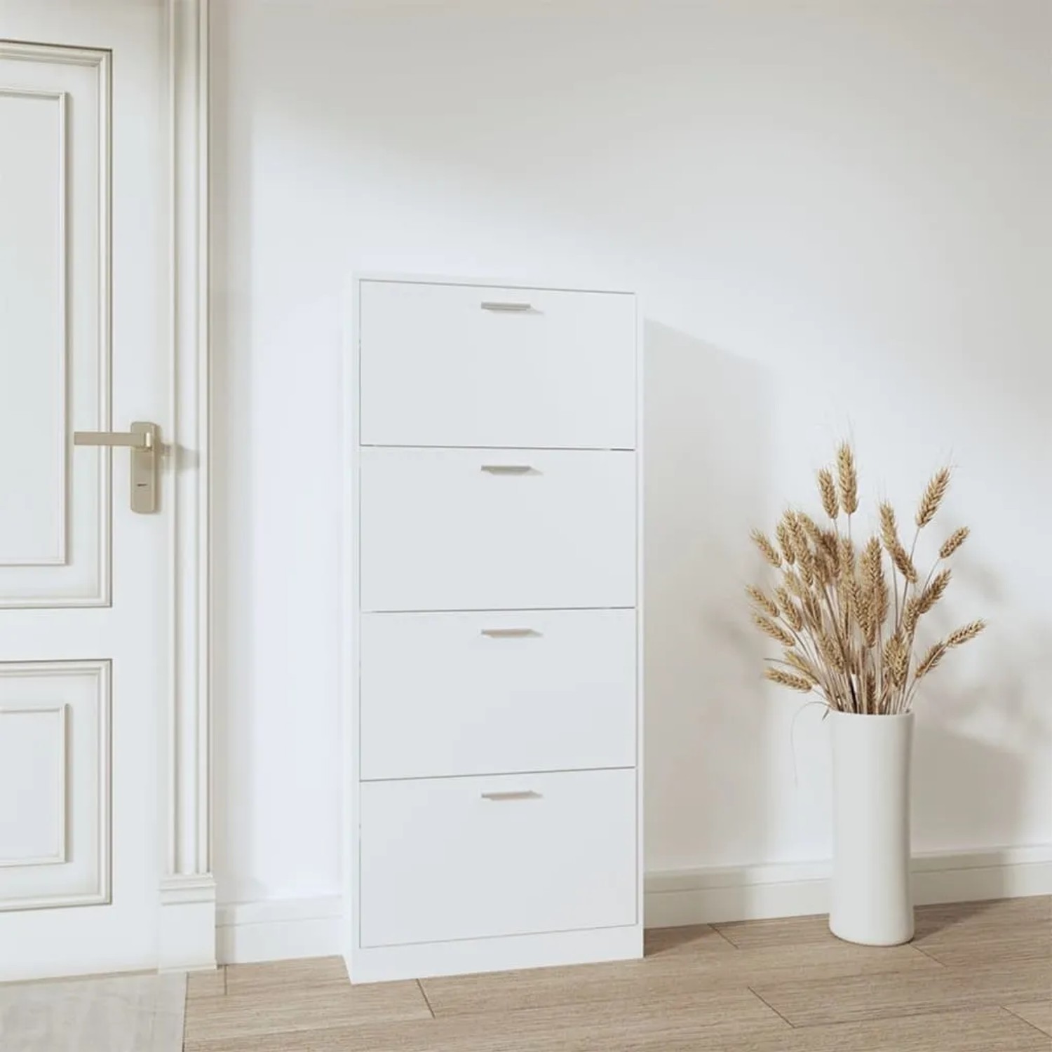 Weißer Schuhschrank aus Holzwerkstoff mit 4 Klappen und silbernen Griffen im Flur. Modernes Design, viel Stauraum.