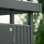 Dunkelgraues Biohort Metall-Gerätehaus HighLine. Detailansicht von Flachdach, Oberlicht und Tür. Modernes Design.