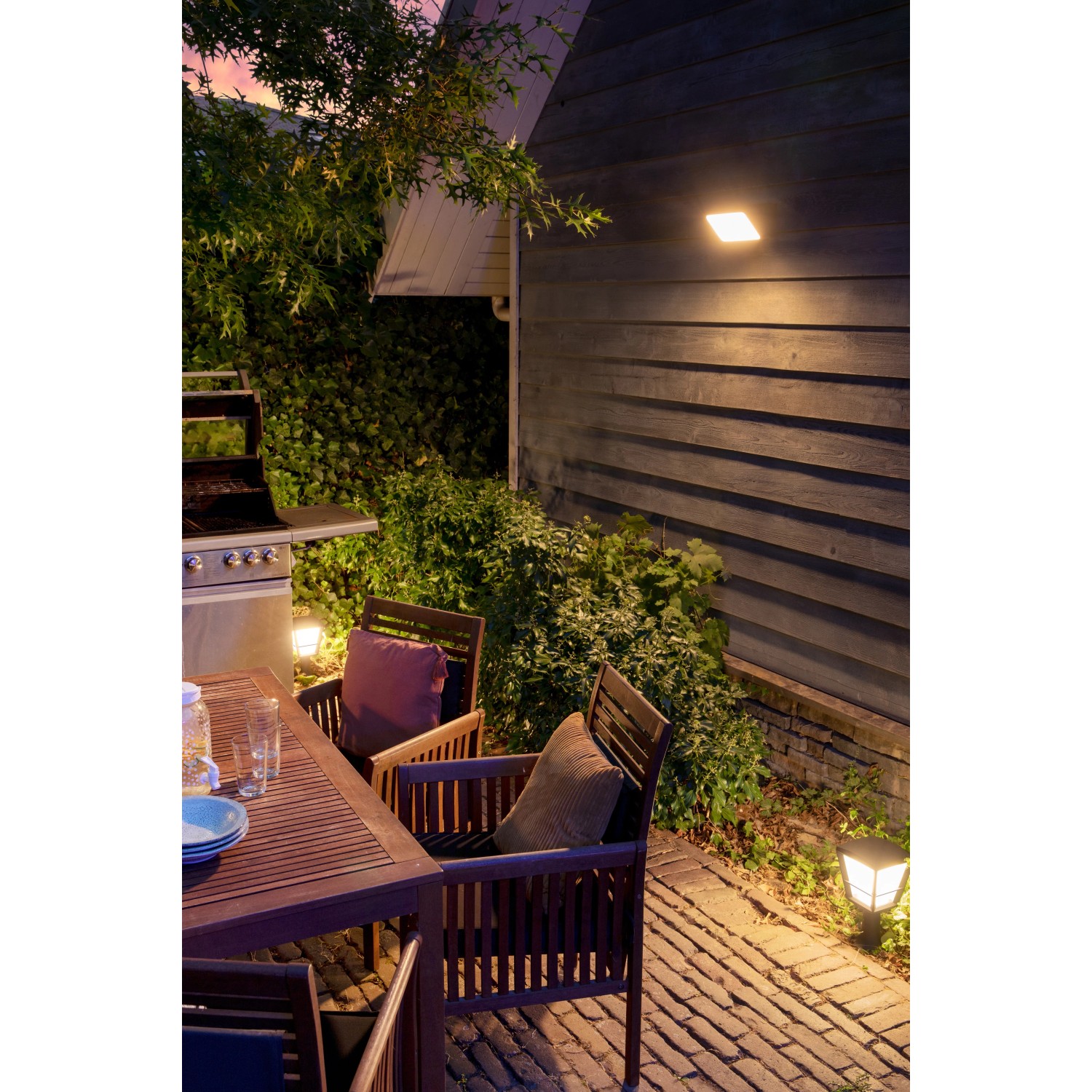 Philips Hue Econic LED-Sockelleuchte im Garten, stimmungsvolle Außenbeleuchtung.