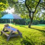 Axi Sand- und Wasser-Picknicktisch Nick grau/blau mit Sonnenschirm im Garten.