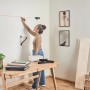 Frau markiert mit Bosch Laser-Wasserwaage UniversalWallLevel eine Linie an der Wand.