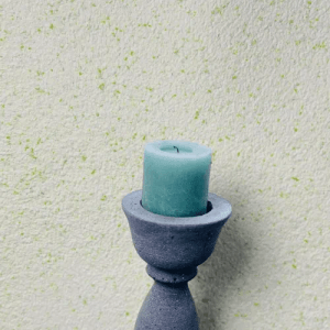 Floxxan Baumwollputz Montana 515 Lemon an Wand mit Kerze im Kerzenständer.