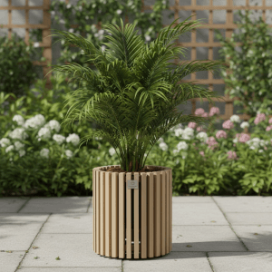 Rundes Pflanzgefäß aus hellem Akazienholz mit vertikalen Lamellen, bepflanzt mit einer Palme, auf einer Terrasse im Garten.