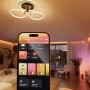 Philips Hue App auf Smartphone steuert dimmbare Leuchten im Wohnzimmer. Smart Home Steuerung für Wandschaltermodul.