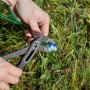 Gardena Verbinder wird mit einer Zange auf einem Begrenzungskabel für Rasenmäher befestigt.