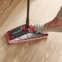 Vileda Ultramax Reinigungssystem in Aktion auf Holzboden mit Fuß auf dem Auswringer.