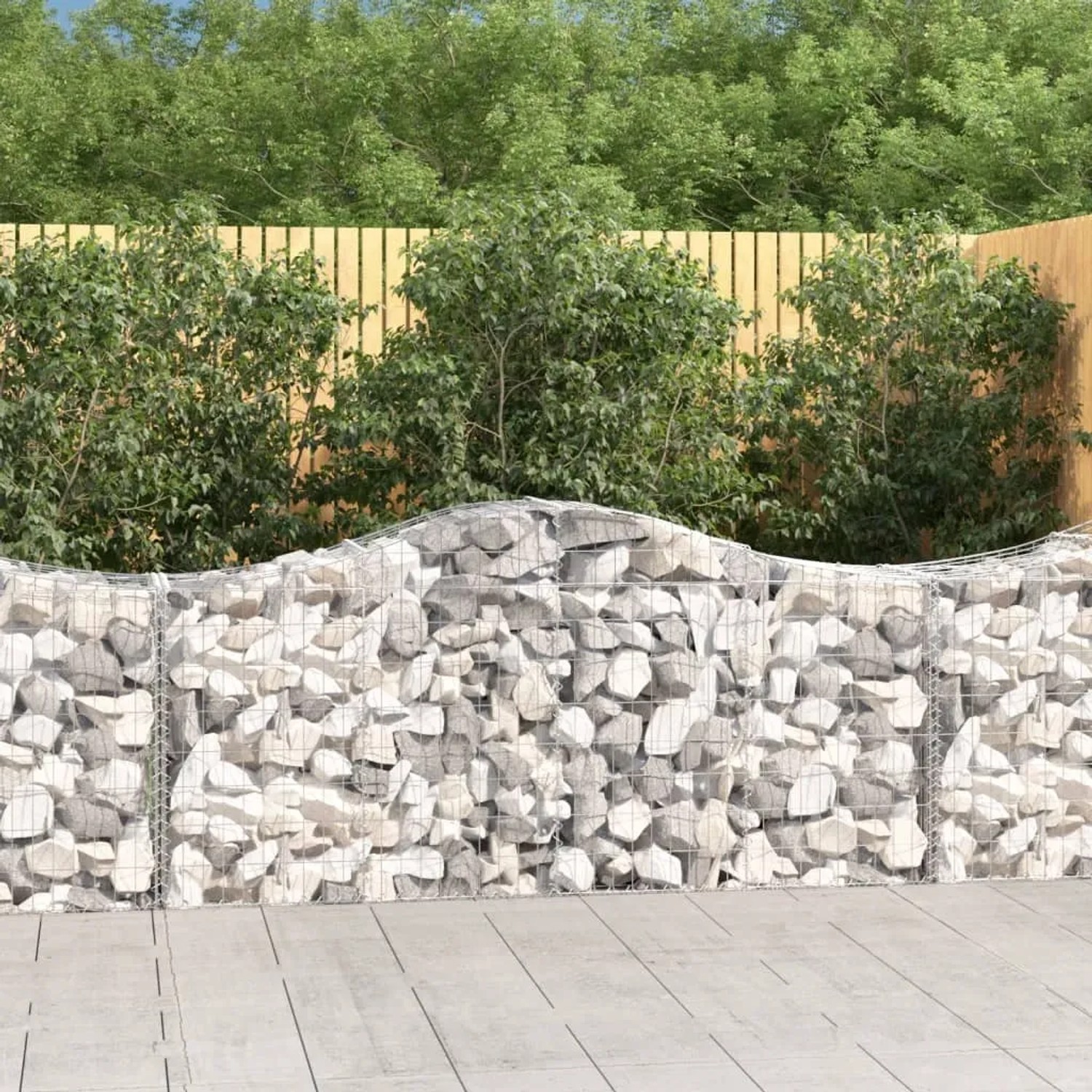 Gefüllte Gabionen mit Hochbogen als dekorativer Sichtschutz im Garten.
