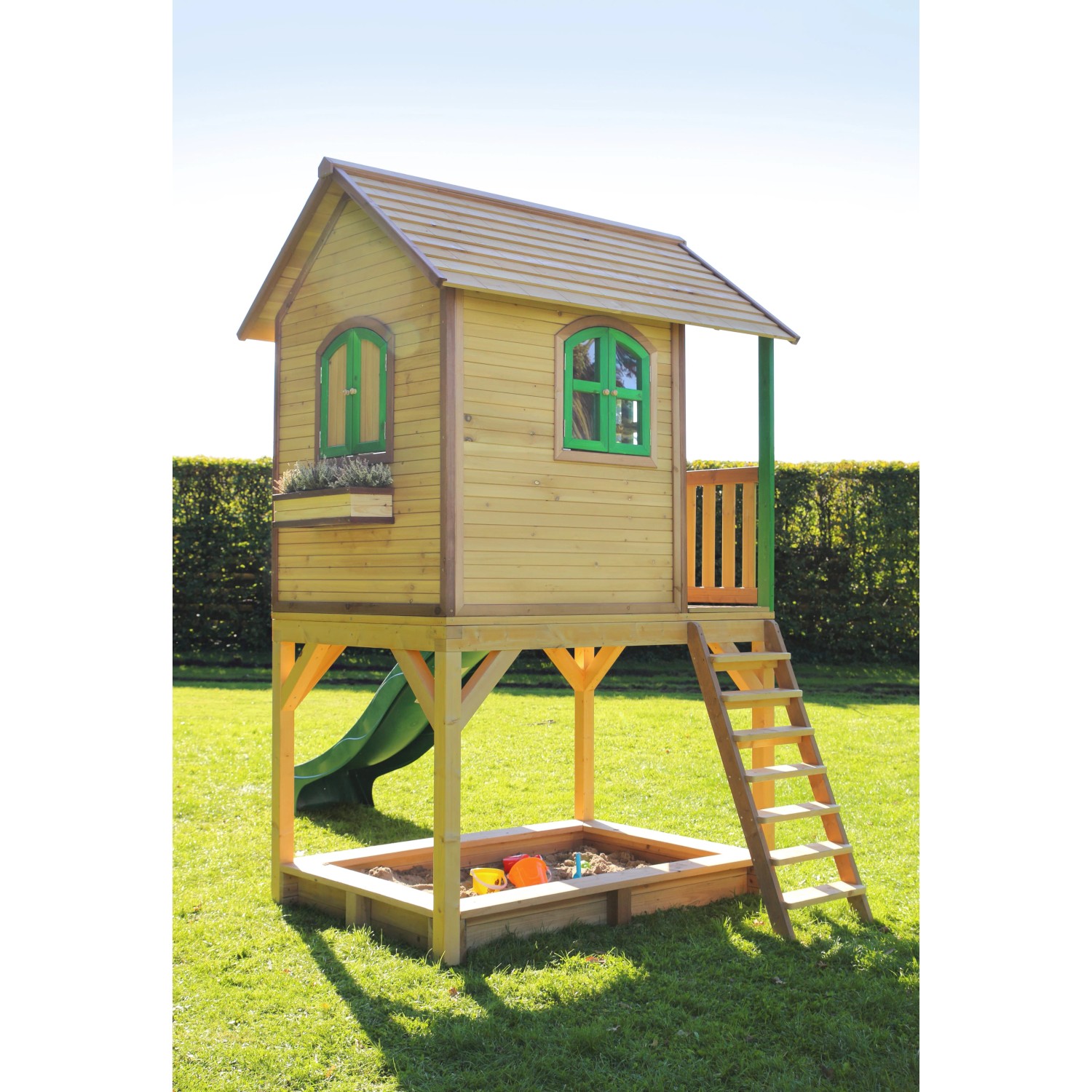Axi Sarah Spielhaus aus Holz mit grüner Rutsche und Sandkasten im Garten.