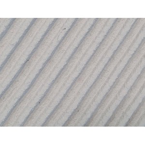Nahaufnahme von grauem Dünnbett-Mauerkleber mit diagonalen Rillen, ideal für Mauersteine und Gartenmauern. 20 kg.