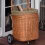 Kaminholzwagen aus Weide mit Rädern und Jute-Auskleidung, gefüllt mit Holz.