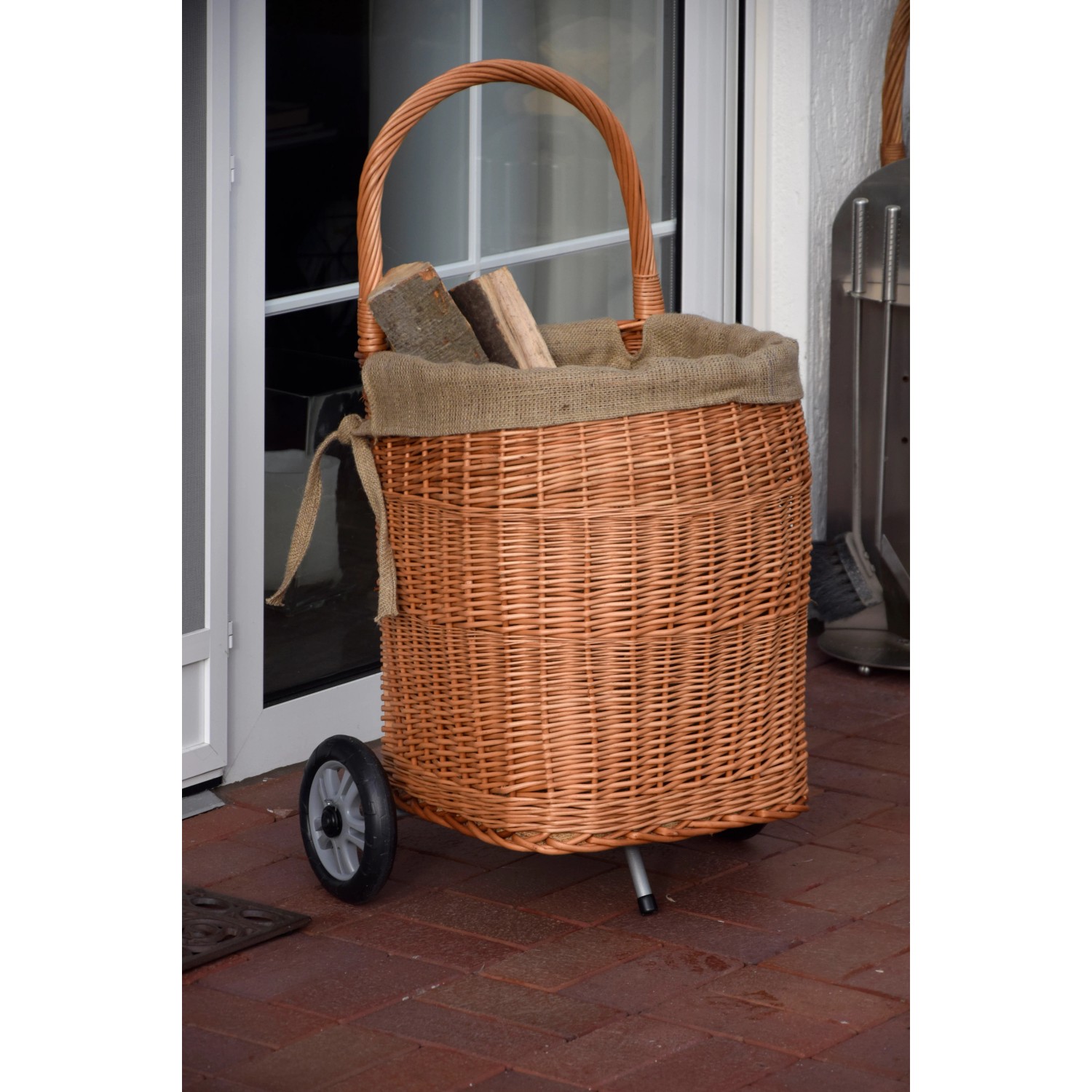 Kaminholzwagen aus Weide mit Rädern und Jute-Auskleidung, gefüllt mit Holz.