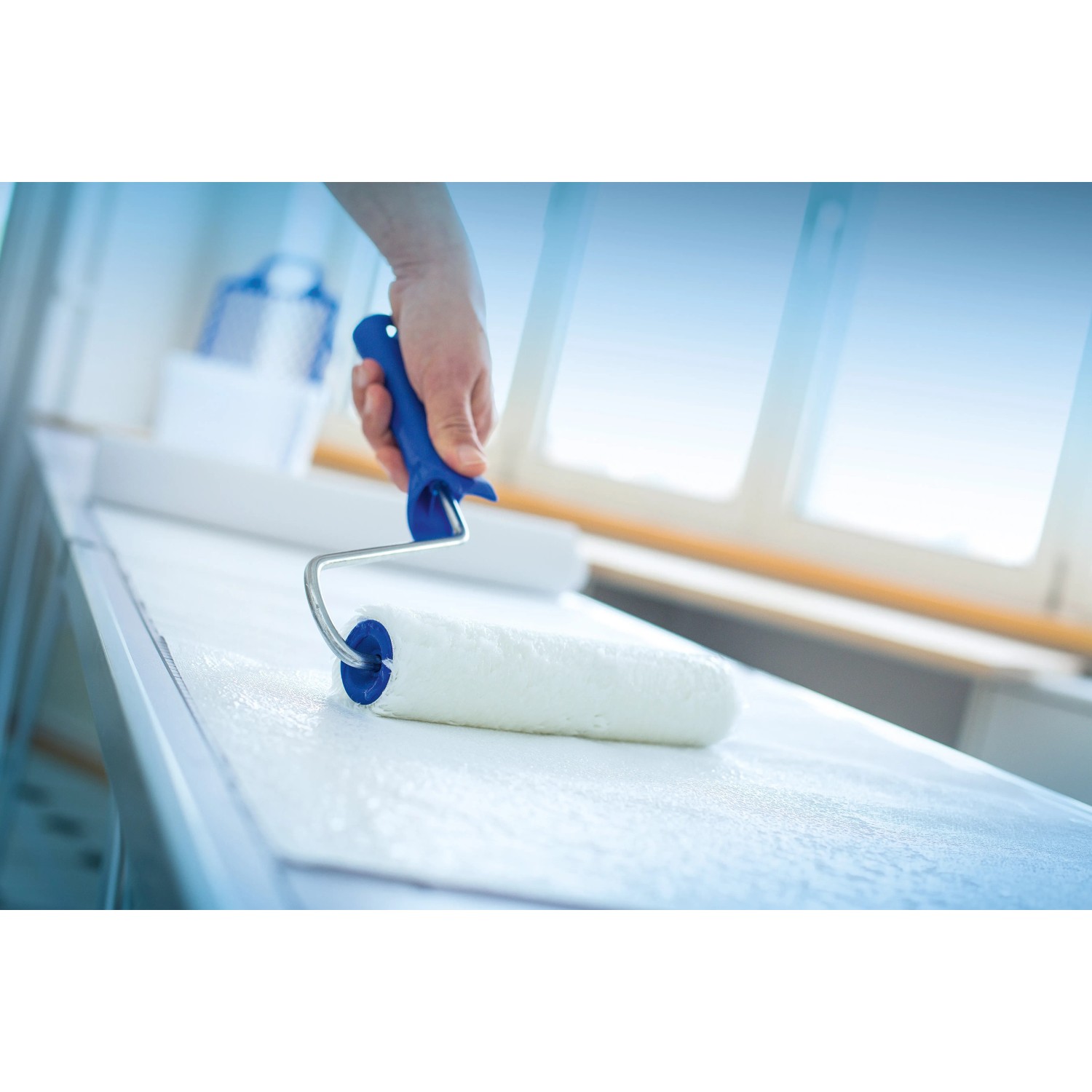 LUX Kleisterroller 18 cm im Einsatz: Tapezieren mit blauem Griff. Ideal für Vliestapeten.