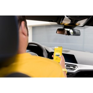 Mann öffnet Garagentor mit Schellenberg Smartphone Garagentoröffner App im Auto.