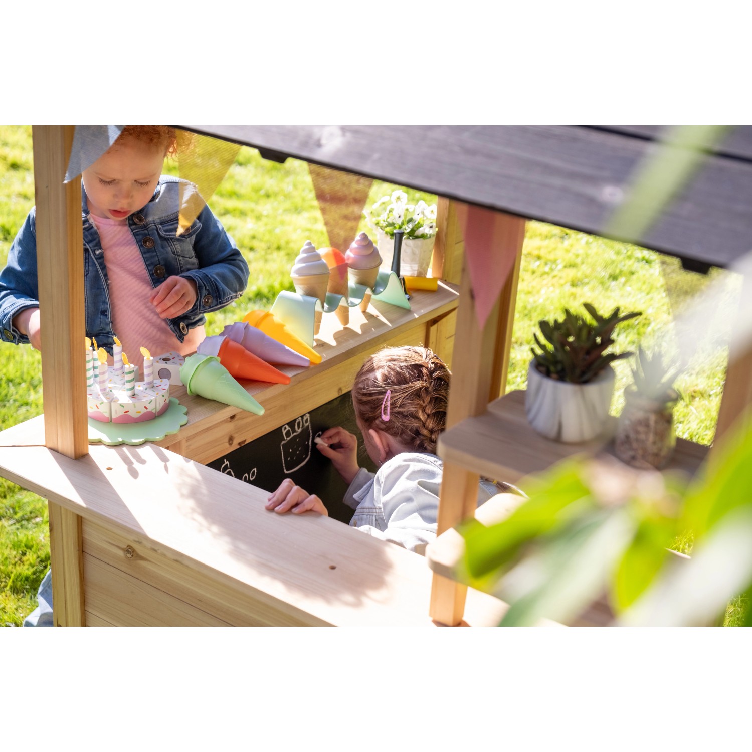 Exit Holzspielhaus Hika mit Kindern beim Spielen im Garten.