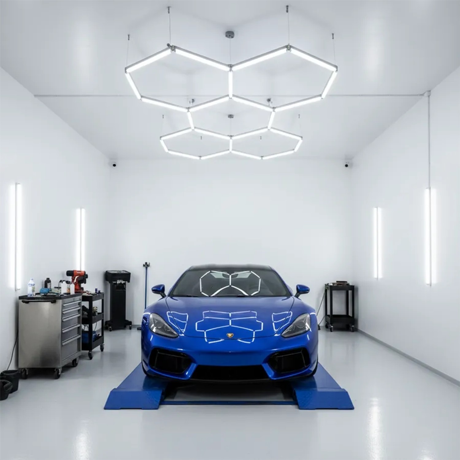 5er Set LUXULA Hexagon LED Deckenleuchte, 40W, kaltweiß, über einem blauen Auto in einer Werkstatt.