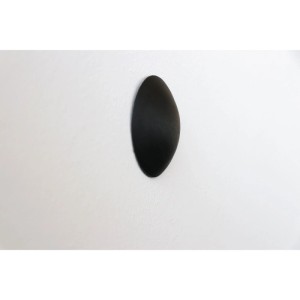 Schwarzer, selbstklebender Wand-Türstopper (Ø 60 mm) aus Kunststoff auf weißer Wand. Schützt Türen & Wände im 6er Set.