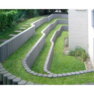 Graue Diephaus Verbundpalisaden als geschwungene Einfassung in einem Garten.