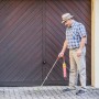 Mann entfernt Unkraut mit Rothenberger Abflammgerät / Ökogärtner mit Piezo-Zündung.