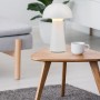 Weiße Reality LED-Tischleuchte Lennon im Pilzdesign auf einem Tisch. Dekorative Lampe für Innen und Außen.