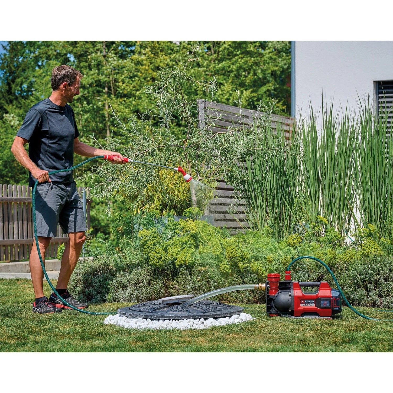 Einhell Aquinna 36/38 F LED Akku-Gartenpumpe im Einsatz mit Gießstab im Garten.