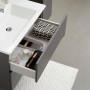 Pelipal Waschbeckenunterschrank Quickset 357, Quarzgrau Matt Touch, mit offener Schublade und Badutensilien.