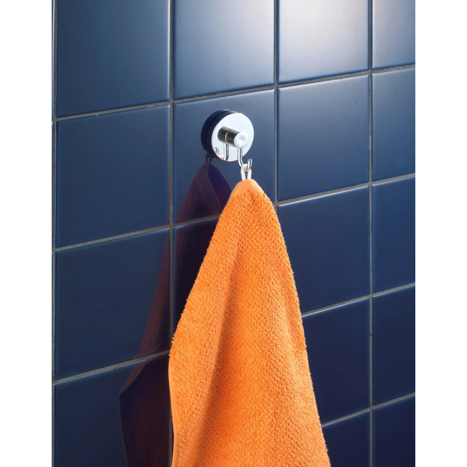 Wenko Vacuum-Loc Hakenset, 2 Chrom-Haken mit orangefarbenem Handtuch an blauer Wand.