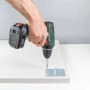 Anschraubplatte aus Stahl (90x90mm) wird mit Akkuschrauber an Möbelbein montiert.
