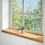 Helle Massivholz-Fensterbank aus Eiche mit natürlicher Maserung, unter einem Fenster mit Blick ins Grüne.