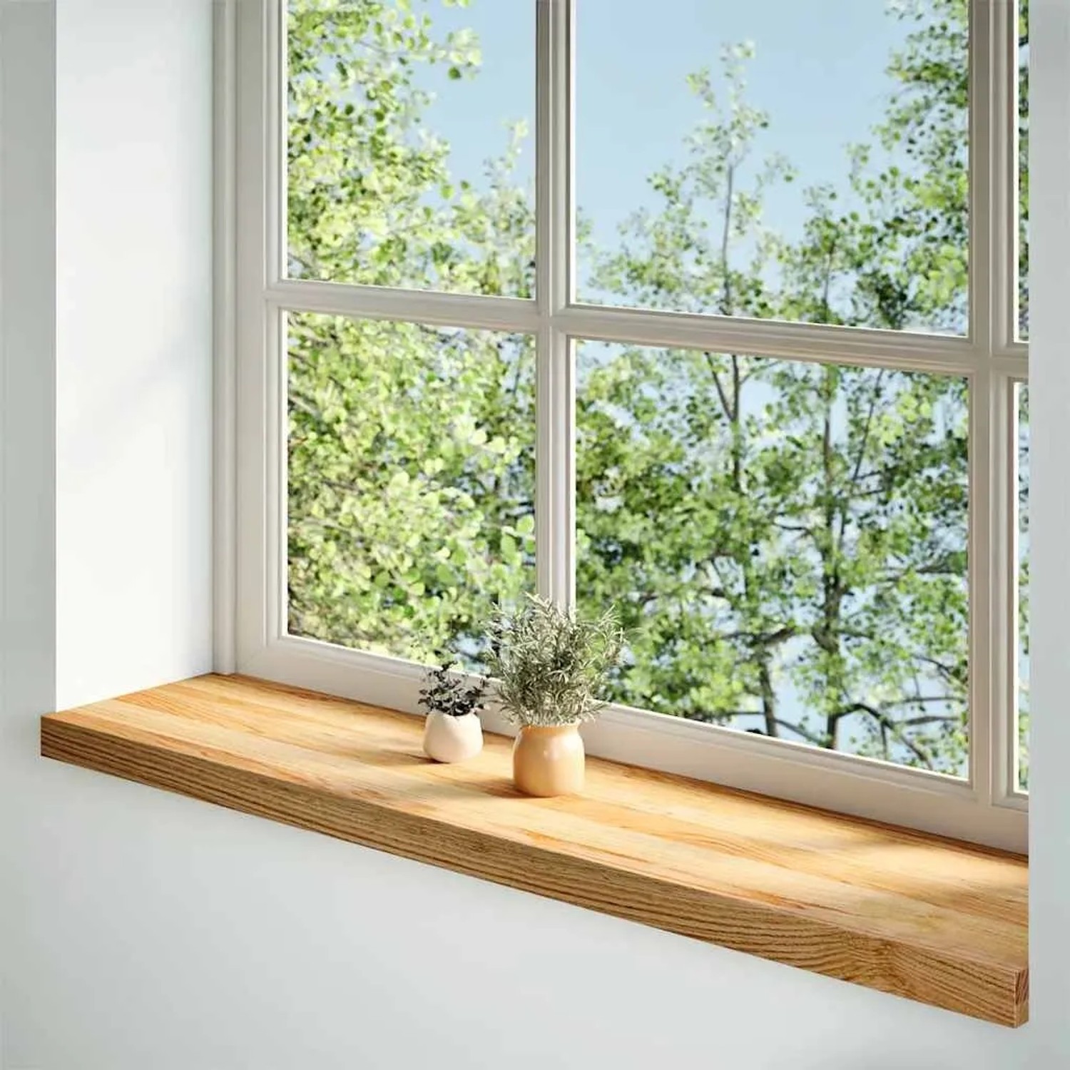 Helle Massivholz-Fensterbank aus Eiche mit natürlicher Maserung, unter einem Fenster mit Blick ins Grüne.
