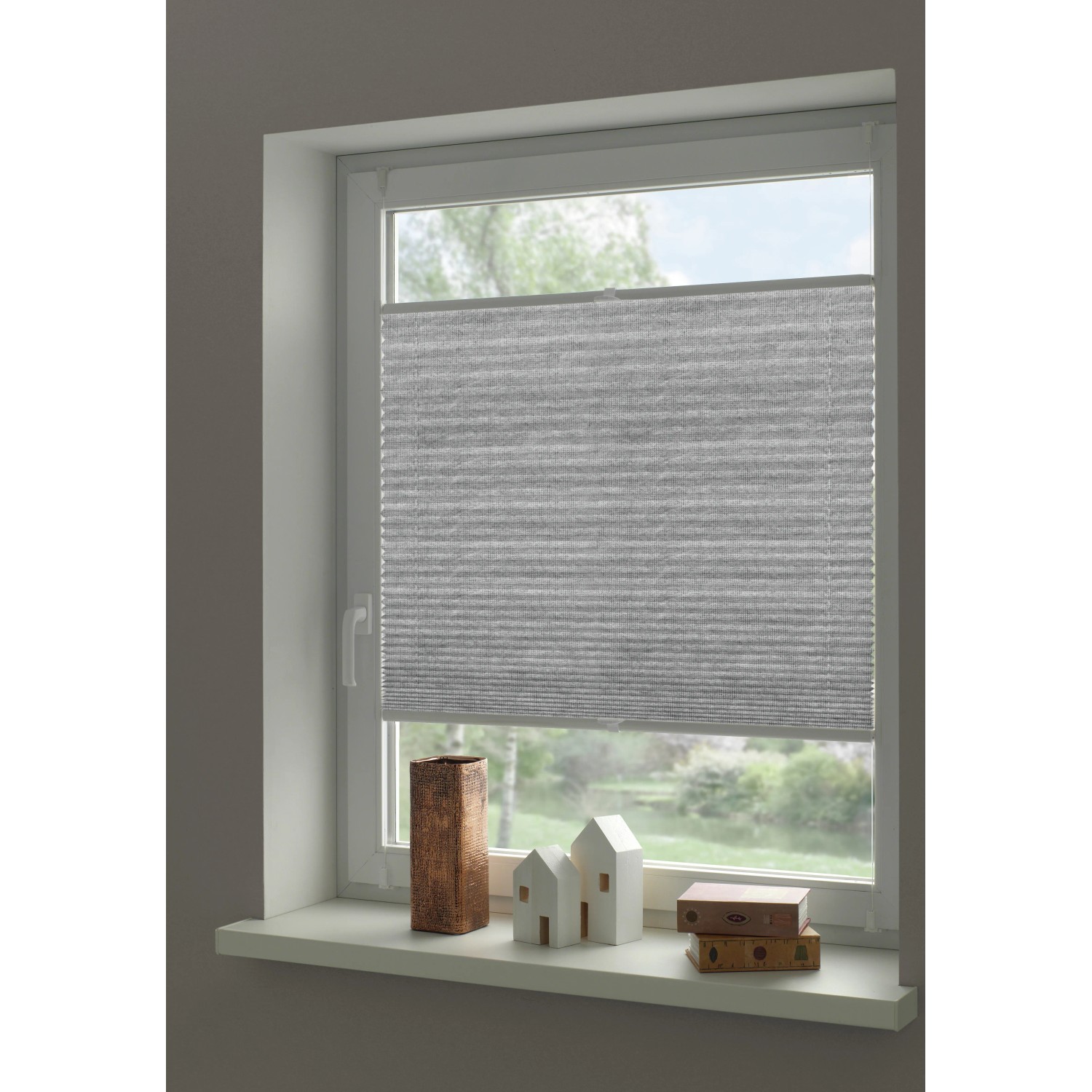 Graues Gardinia Plissee Concept am Fenster, blickdicht und einfach zu montieren.