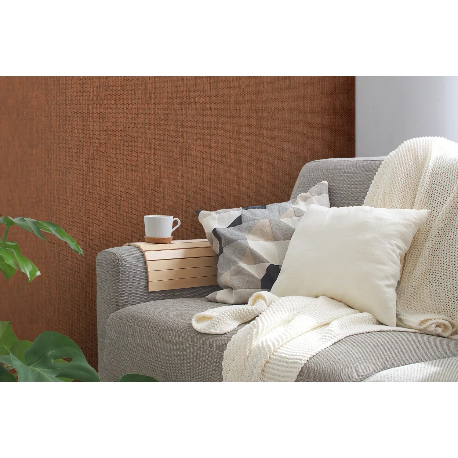 Rot strukturierte Vliestapete Uni Matt an Wand hinter Sofa mit Kissen und Decke.