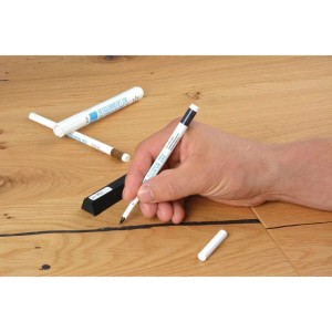 Hand korrigiert Holzboden mit Bao Flex-Pen Lack-Retuschierstift für Holz. Präzise Farbkorrektur von Holzoberflächen.