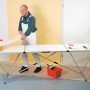 LUX Multifunktionstisch mit Alu-Gestell beim Tapezieren. Tapeziertisch mit Werkzeug und Person.