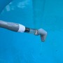 Pool-Handsauger im Einsatz: Akku-Poolsauger reinigt Poolwasser, weiß-graues Design.