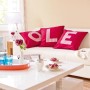 Wohnzimmer mit Wandfarbe Schöner Wohnen My Colour My Sisal matt, rote Kissen mit weißen Buchstaben.