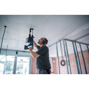 Mann bohrt mit Bosch Professional Akku-Bohrhammer GBH 18V-28 DC in Decke.