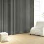Glööckler Vliestapete Imperial Welle in Anthrazitmetallic im Raum mit Sessel.