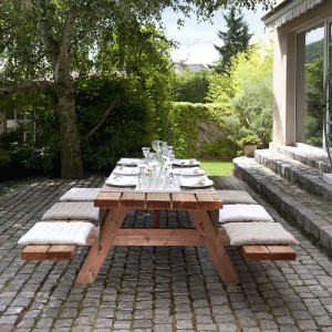 Gedeckter Kordo Picknicktisch aus Holz für 6-8 Personen im Garten.